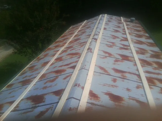 Rusted metal roof panels with new wood purlins before replacement — Storm Damage Roof Repair in Olathe by Roofing Brothers