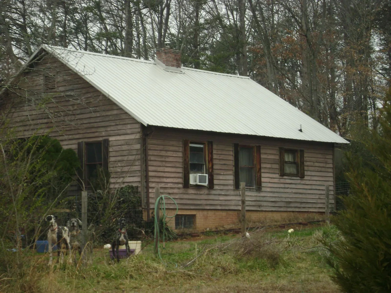 White metal roof on an old wood sided farmhouse, from a Metal Roof Installation job in Olathe